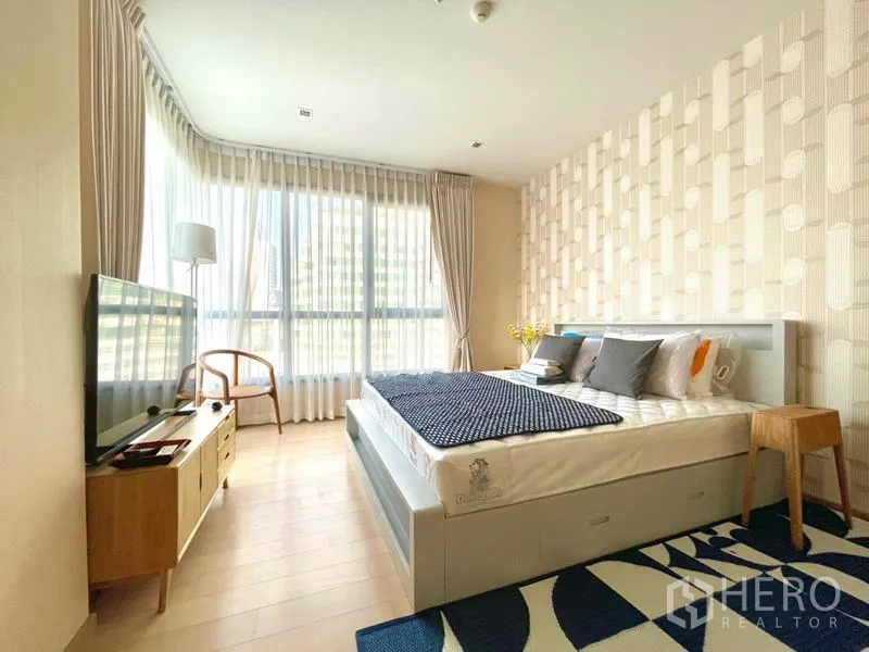 คอนโด ให้เช่าหรือขายในWatthana, Bangkok - ห้องนอนหลักเตียงใหญ่ ผนังลาย และกระจกเต็มบานรับแสงธรรมชาติ