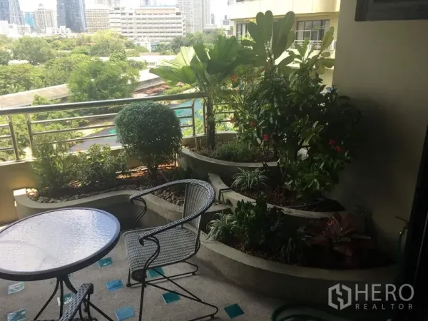 公寓 出租在Sathon, Bangkok - 阳台设圆桌椅与内置花槽绿植，俯瞰城市与树梢。