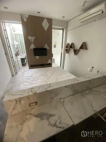 店屋 出租或出售在Khlong Toei, Bangkok - 卧室设大理石台面工作区、墙挂电视隔断与空调。