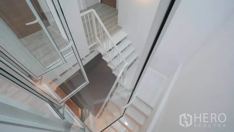联排别墅 出租在Khlong Toei, Bangkok - 白色楼梯配玻璃扶手与挑空采光井