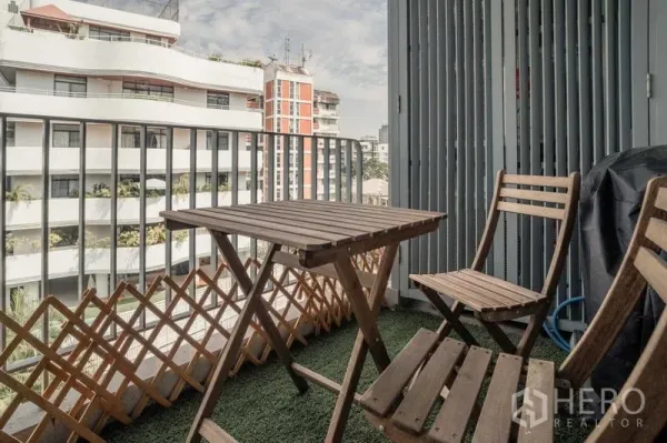 Condominium for sale in Watthana, Bangkok - Private balcony with bistro table and chairs overlooking nearby buildings.