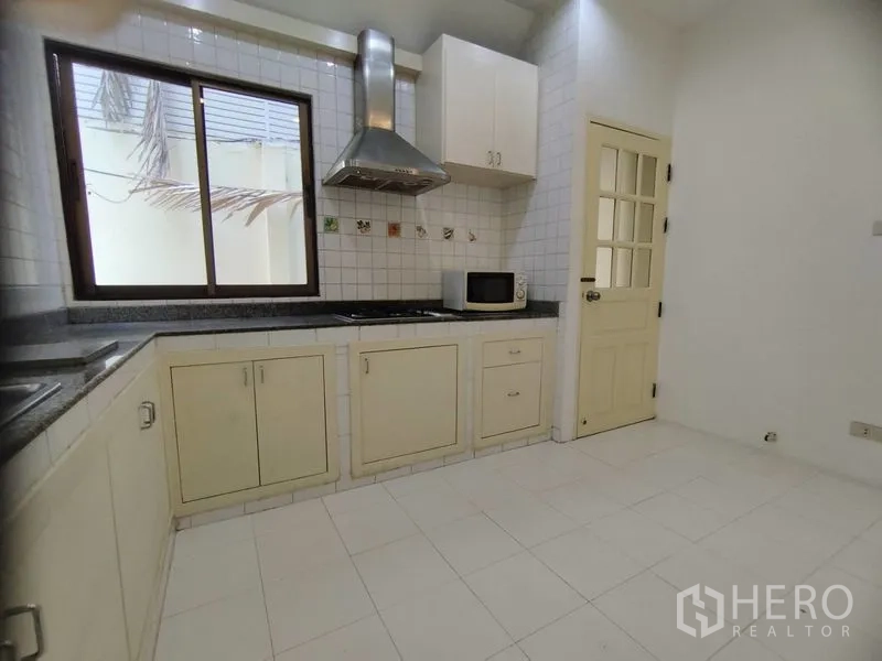 บ้าน ให้เช่าในWatthana, Bangkok - ห้องครัวปูกระเบื้องสีขาว เตาแก๊ส เครื่องดูดควัน และตู้เก็บของ