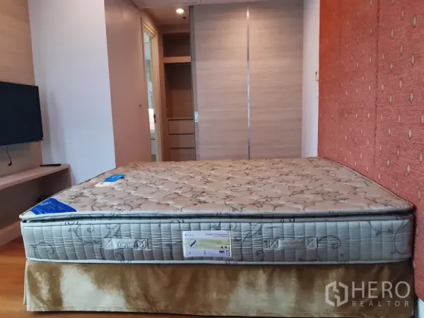 คอนโด ให้เช่าหรือขายในKhlong Toei, Bangkok - ห้องนอนหลักมีเตียงขนาดใหญ่ ชั้นวางทีวี และตู้เสื้อผ้าบานเลื่อน