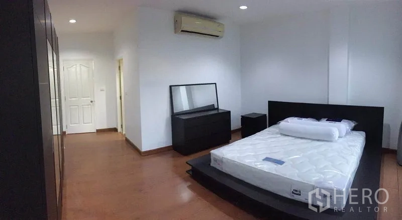 ทาวน์เฮาส์ ให้เช่าในLat Phrao, Bangkok - ห้องนอนพร้อมเตียงแพลตฟอร์ม โต๊ะเครื่องแป้ง เครื่องปรับอากาศ และประตูสีขาว