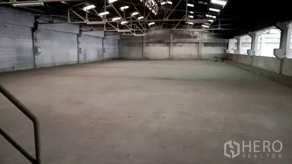 Warehouse for rent in Nakhon Pathom - Wide open warehouse hall with high steel truss roof, skylights and concrete flooring.