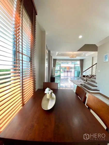 ทาวน์เฮาส์ ให้เช่าในPrawet, Bangkok - มุมมองจากโต๊ะอาหารไปยังโถงนั่งเล่นแบบเปิดโล่ง ประตูสไลด์หน้า และบันได.