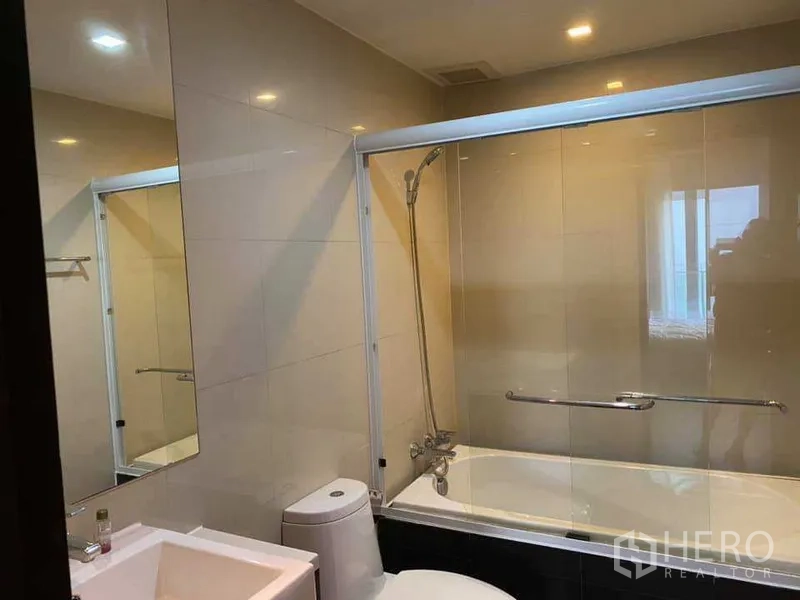 คอนโด ให้เช่าในKhlong Toei, Bangkok - ห้องน้ำสมัยใหม่ อ่างอาบน้ำพร้อมฉากกั้นกระจก อ่างล้างหน้า และผนังโทนสว่าง