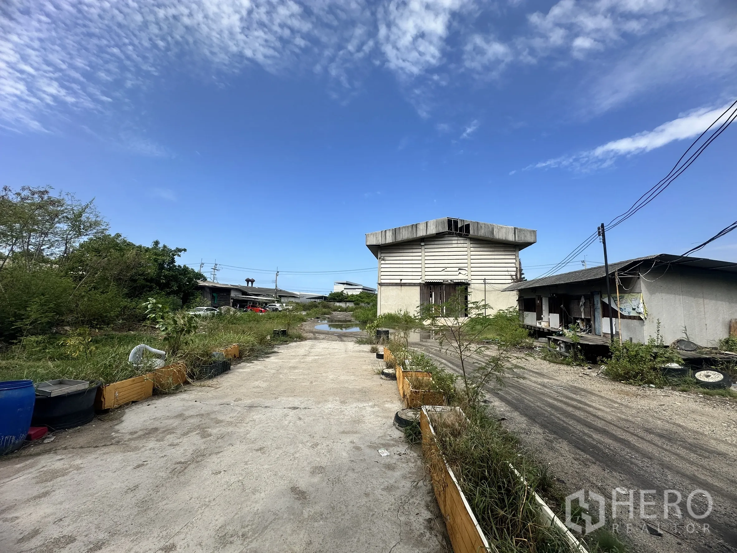 Land for sale in Mueang Samut Prakan, Samut Prakan - Outdoor yard with concrete driveway, warehouse building and ancillary structures.