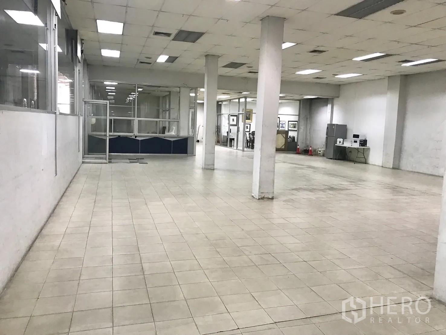 仓库 for rent in Phra Khanong, Bangkok - 室内大面积瓷砖地面，立柱、天花照明与玻璃隔断办公室。
