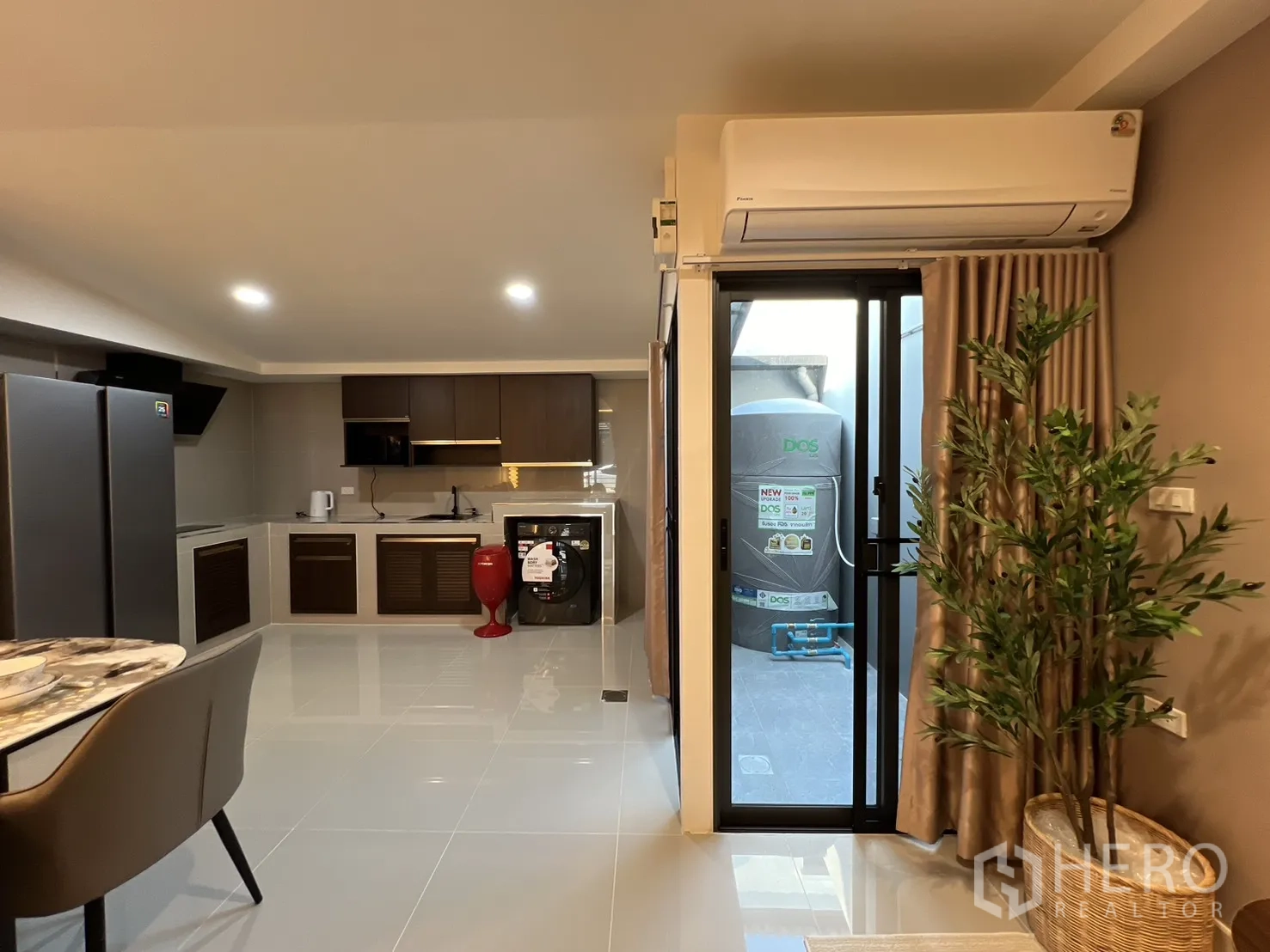 Townhouse for rent in Bang Phli, Samut Prakan - Kitchen with sliding glass door to a utility patio, air conditioner, washer and fridge.
