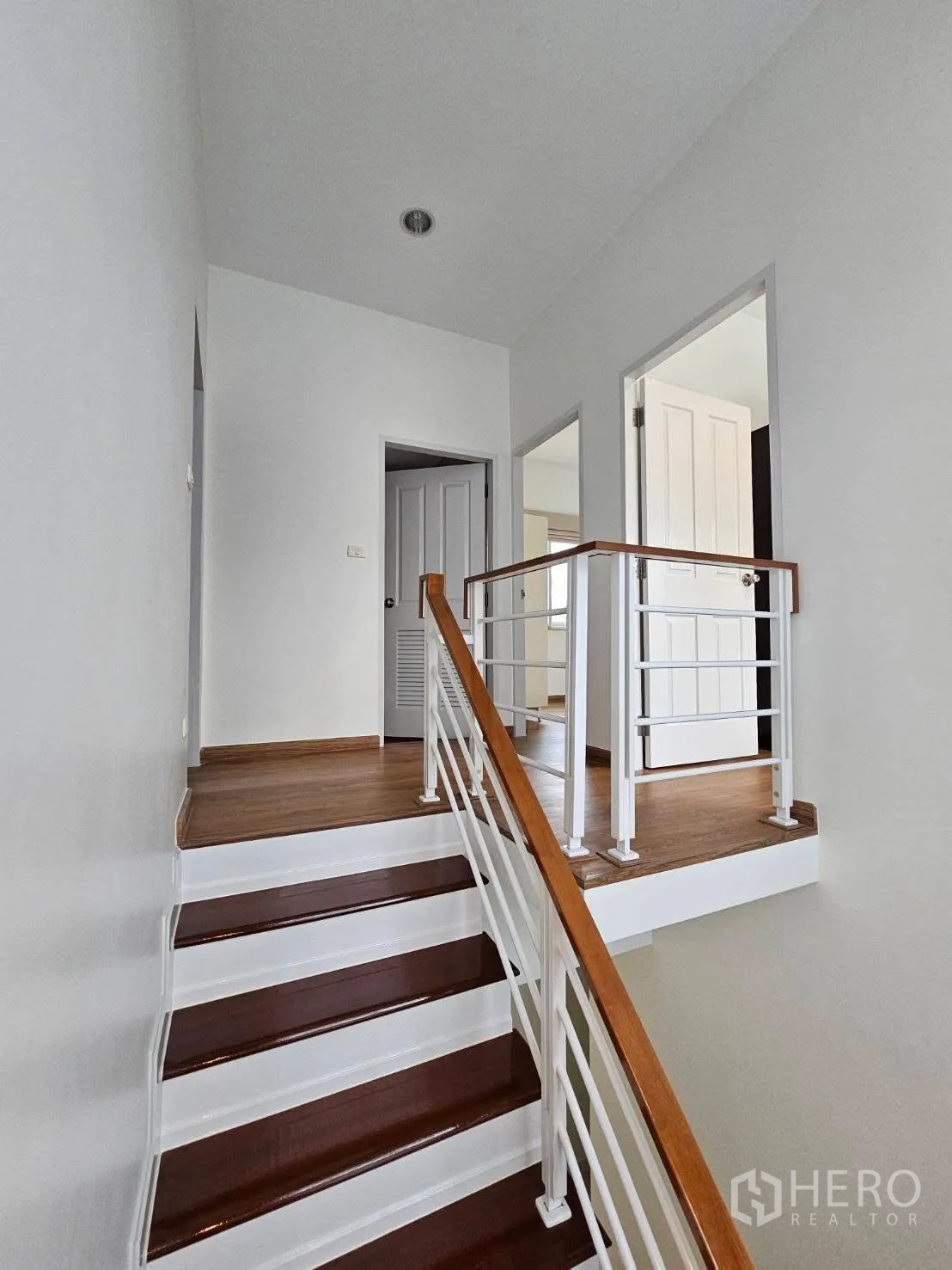 独栋房屋 for rent in Bang Phli, Samut Prakan - 二层走廊与楼梯，木地板和白色扶手。