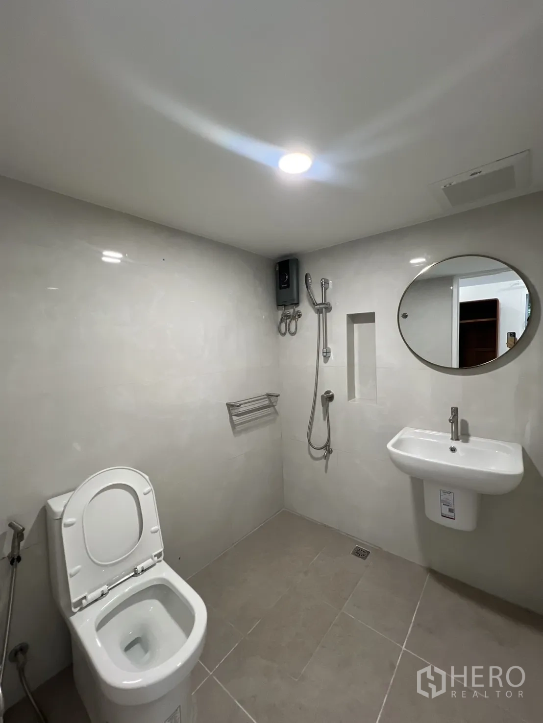 Detached House for rent in Saphan Sung, Bangkok - Ground-floor bathroom with handheld shower, toilet and round mirror.