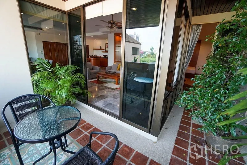 อพาร์ทเมนท์ ให้เช่าในWatthana, Bangkok - ระเบียงพร้อมชุดโต๊ะบิสโทร กระถางต้นไม้ และประตูกระจกเข้าสู่ห้องนั่งเล่น