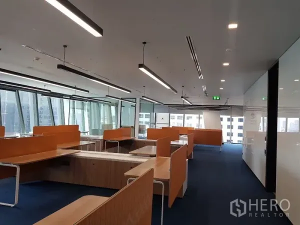สำนักงาน ให้เช่าในHuai Khwang, Bangkok - พื้นที่สำนักงานแบบโอเพ่นแพลน โต๊ะทำงานยาว ฉากกั้นสีส้ม ผนังกระจก และวิวเมืองผ่านหน้าต่างบานใหญ่