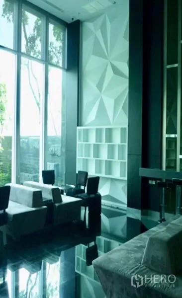 คอนโด ให้เช่าในRatchathewi, Bangkok - เลาจน์ส่วนกลางพร้อมหน้าต่างสูง ผนังลายเรขาคณิต และโซฟานุ่ม