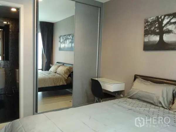 คอนโด ให้เช่าในKhlong Toei, Bangkok - ห้องนอนตกแต่งครบ มีตู้เสื้อผ้าบานกระจก โต๊ะทำงาน และทางเข้าห้องน้ำในคอนโดโมเดิร์น