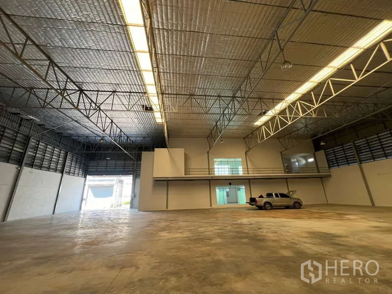 货栈 出租在Prawet, Bangkok - 宽阔仓库内部，天窗灯带与停放在混凝土地面的皮卡。