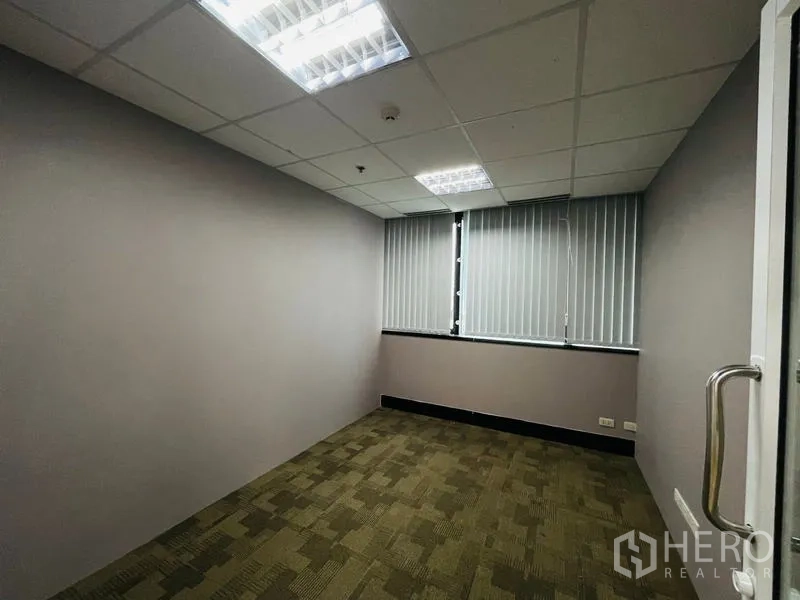 Office Space for rent - Compact carpeted office with windows and vertical blinds.