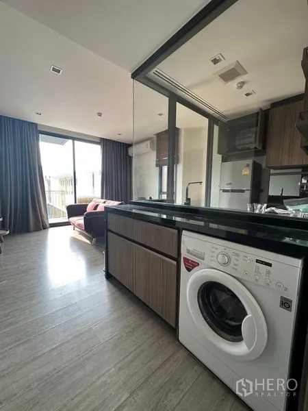 คอนโด ให้เช่าในWatthana, Bangkok - เคาน์เตอร์ครัวพร้อมเครื่องซักผ้า หันหน้าไปยังโซนนั่งเล่นและระเบียง