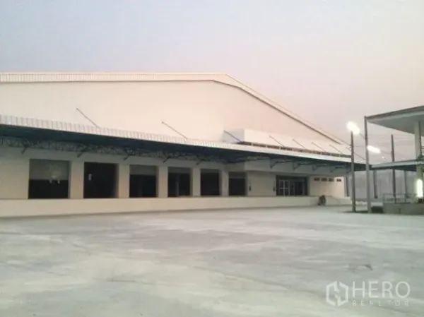 คลังสินค้า ให้เช่าในBang Sao Thong, Samut Prakan - ด้านนอกโกดังพร้อมหลังคาคลุมท่าขนถ่ายและลานคอนกรีตกว้าง ในบางเสาธง