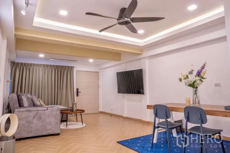 联排别墅 出租在Khlong Toei, Bangkok - 宽敞客厅，吊扇、壁挂电视与餐桌椅