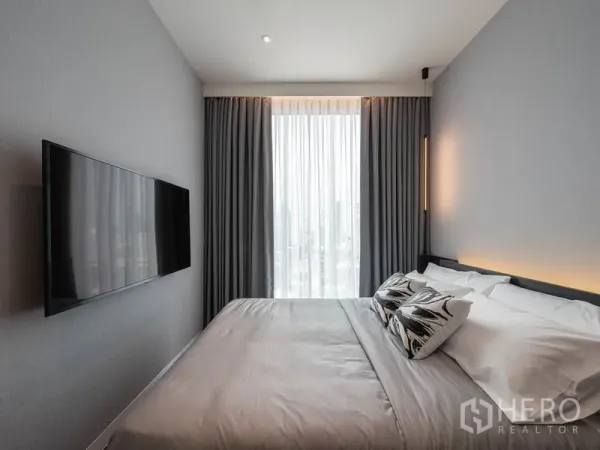 คอนโด ให้เช่าในWatthana, Bangkok - ห้องนอนหลักพร้อมทีวีติดผนัง ผ้าม่านสีเทา และหน้าต่างวิวเมือง