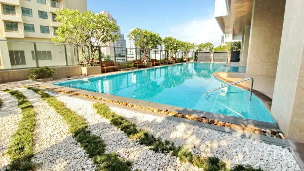 公寓 出租在Khlong Toei, Bangkok - 屋顶游泳池配躺椅与绿植，可眺望城市天际线。