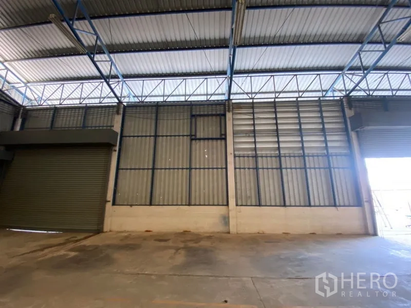 工厂 出租在Lat Lum Kaeo, Pathum Thani - 装卸区的双卷闸门与通风墙面。
