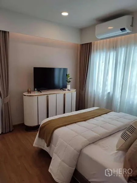 Detached House for rent in Bang Phli, Samut Prakan - Guest bedroom with bed, TV console, curtains and air-conditioning.