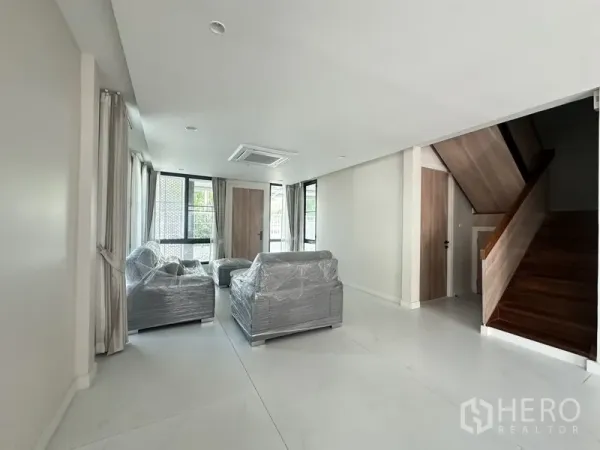 ทาวน์เฮาส์ ให้เช่าในWatthana, Bangkok - ห้องนั่งเล่นสว่าง โซฟาใหม่และบันไดไม้