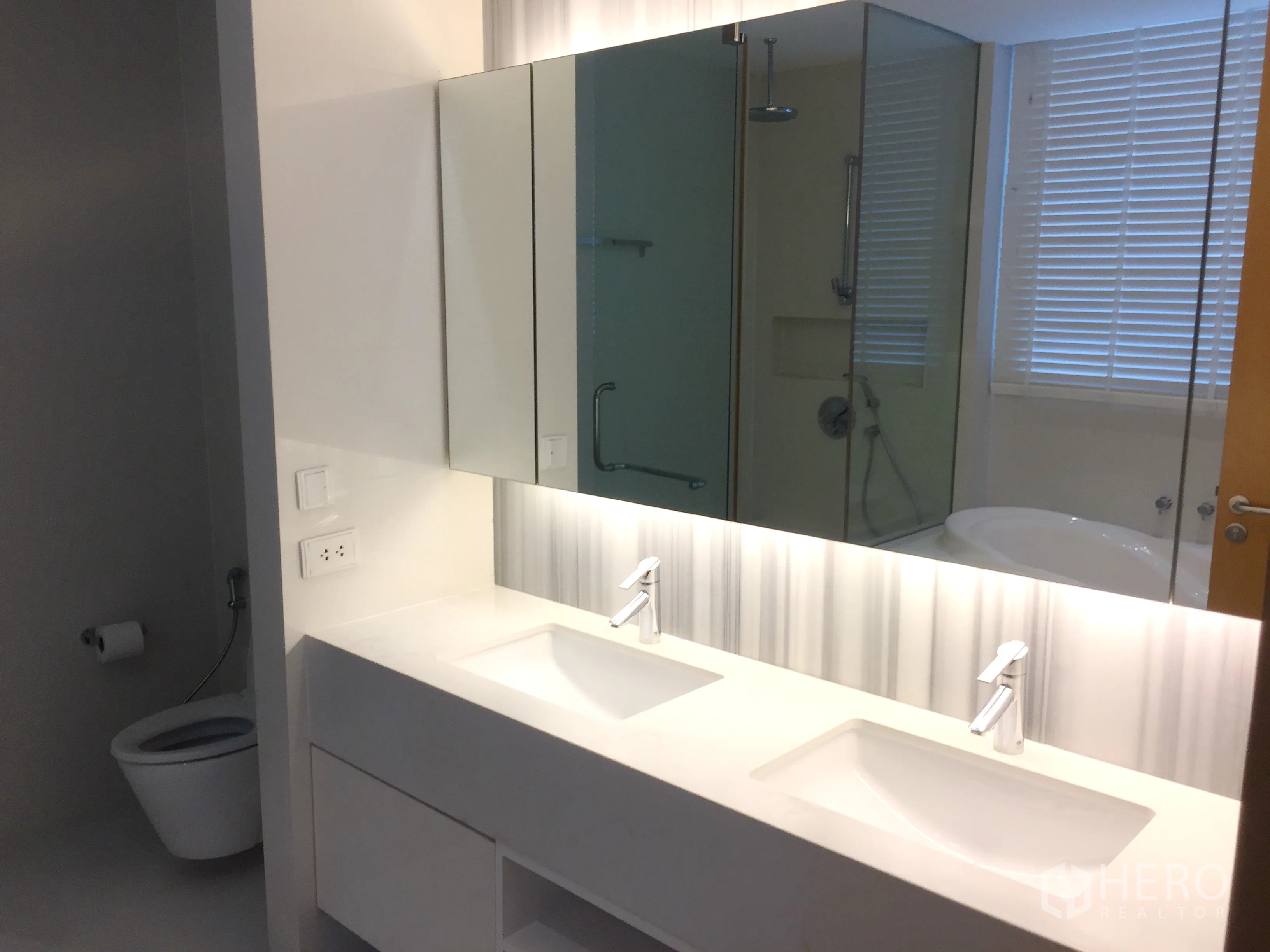 Condominium for rent or sale in Watthana, Bangkok - Modern bathroom featuring a double vanity, large mirror, separate shower and bathtub.