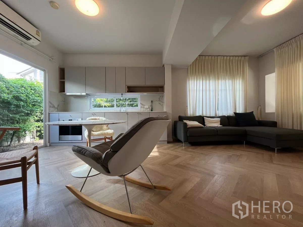 Townhouse for rent in Bang Phli, Samut Prakan - Open-plan living, dining and minimalist kitchen with garden view windows.