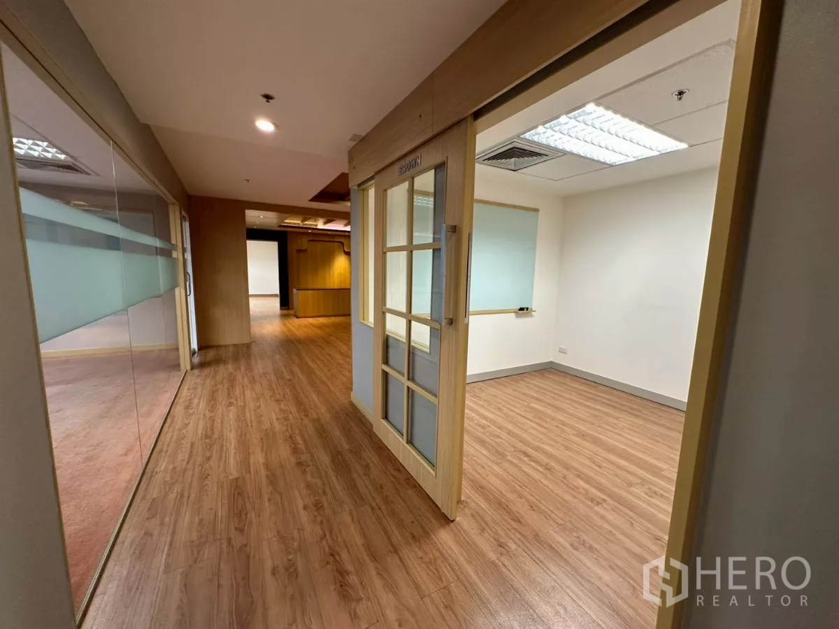 Office Space for rent in Khlong Toei, Bangkok - Hallway leading to enclosed office rooms with frosted glass panels.