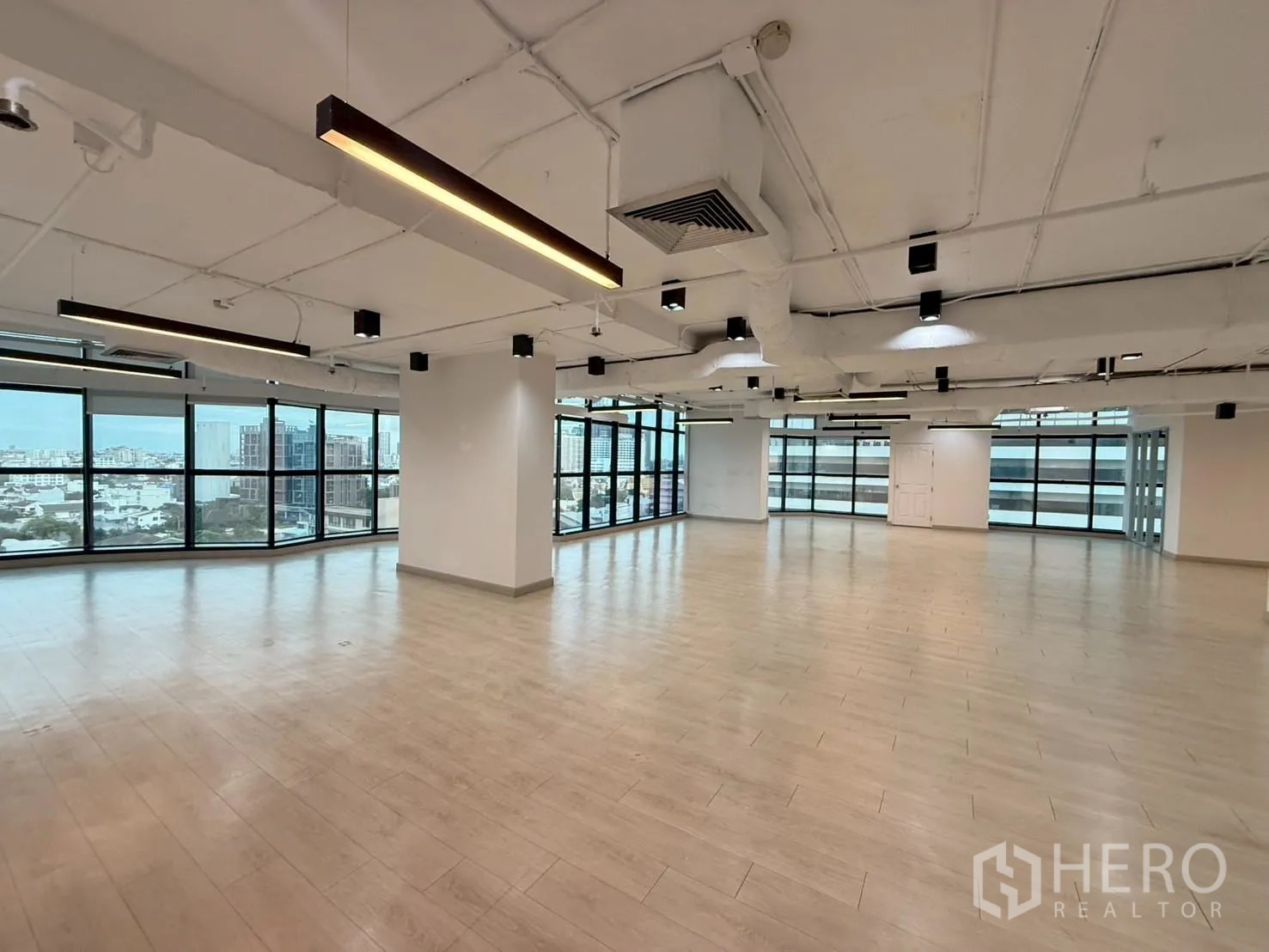 Office Space for rent in Watthana, Bangkok - Large workspace with wraparound windows, columns, and city skyline views.