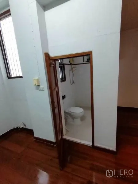 Detached House for rent in Pathum Wan, Bangkok - Compact bathroom with white tiles, toilet and electric shower.