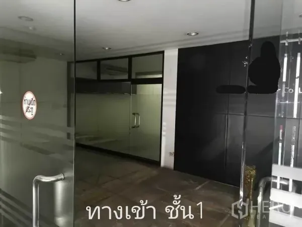 Home Office for rent in Khlong Toei, Bangkok - Ground-floor entrance with glass doors and a black feature wall in a home office.