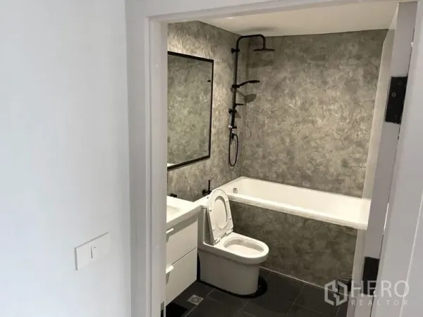 คอนโด ให้เช่าในWatthana, Bangkok - ห้องน้ำมีอ่างอาบน้ำ เรนชาวเวอร์ และกระจกบานกว้าง โทนสีเทาเท็กซ์เจอร์.