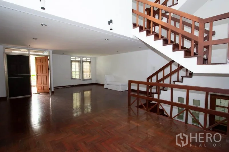 ทาวน์เฮาส์ ให้เช่าในKhlong Toei, Bangkok - ห้องนั่งเล่นกว้าง พื้นไม้ปาร์เกต์และบันไดไม้เปิดโล่ง