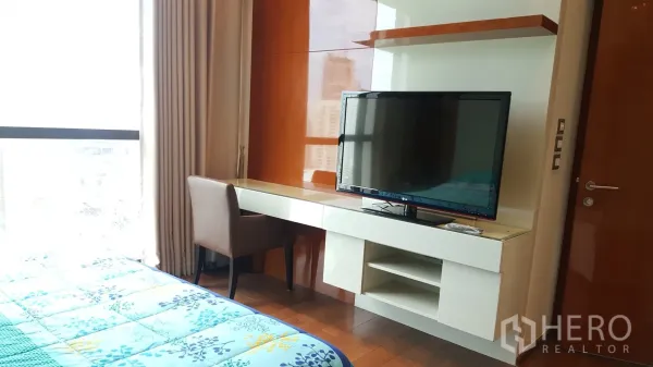 公寓 出租或出售在Khlong Toei, Bangkok - 卧室书桌与搁架一体化设计，配平板电视与座椅。