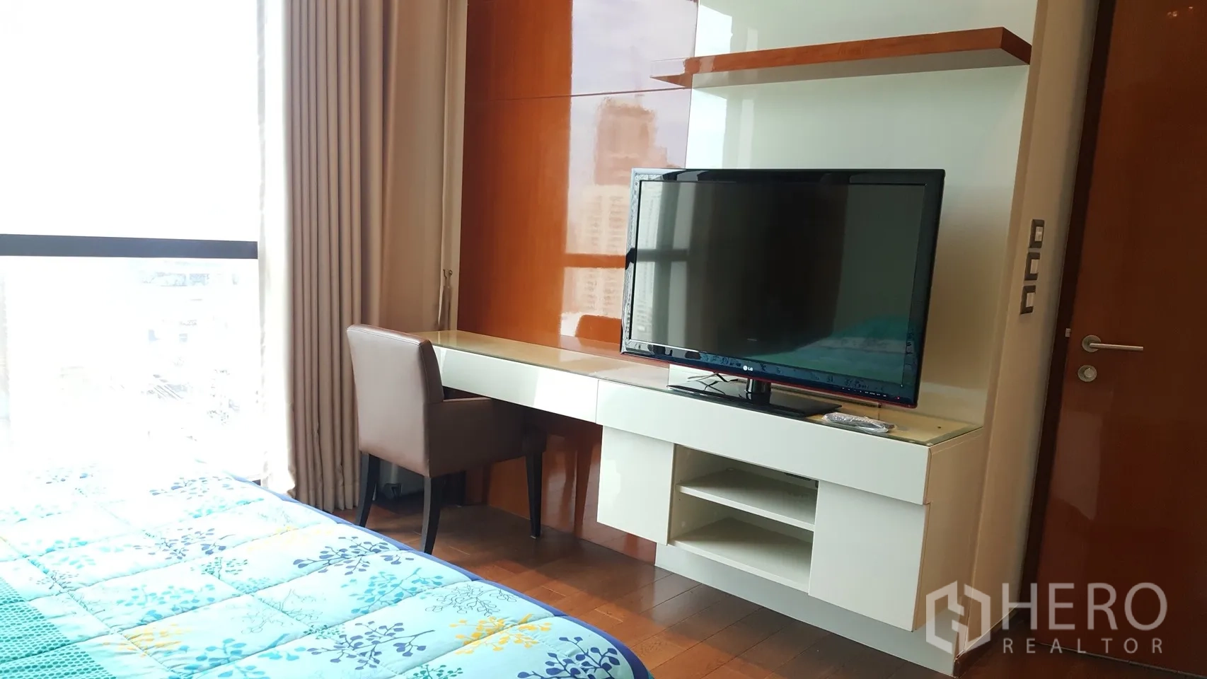 公寓 出租或出售在Khlong Toei, Bangkok - 卧室书桌与搁架一体化设计，配平板电视与座椅。