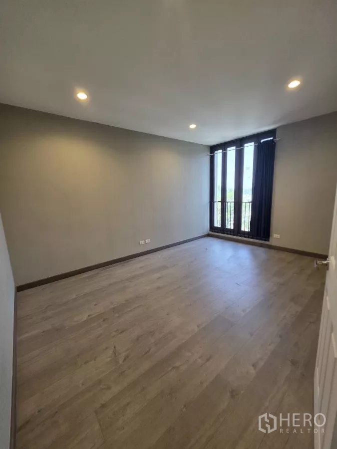 Home Office for rent in Pak Kret, Nonthaburi - Bright private office room with wood floors and tall windows overlooking greenery.