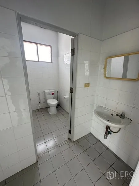 工厂 出租在Pathum Thani - 洁净的瓷砖卫生间，配有坐便器、洗手盆与窗户通风。