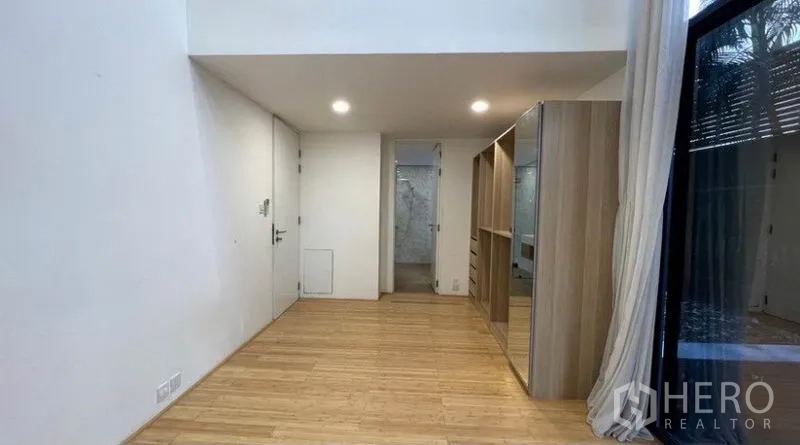 Condominium for rent in Watthana, Bangkok - Primary bedroom with built-in wardrobes, sliding doors, and access to an ensuite bathroom.