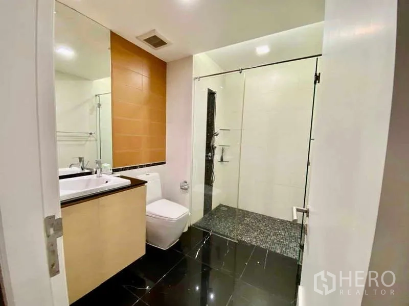 公寓 出租或出售在Sathon, Bangkok - 客卫配玻璃淋浴间、台盆与黑色地砖。