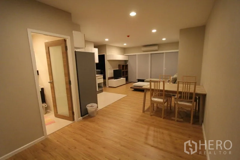 公寓 出租在Pathum Wan, Bangkok - 宽敞用餐区通向客厅，嵌灯与木地板。