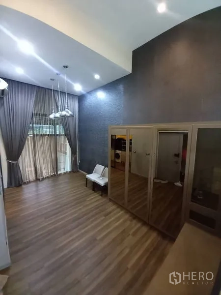 ทาวน์เฮาส์ ให้เช่าในSuan Luang, Bangkok - ห้องอเนกประสงค์เพดานสูง โคมแขวน ผ้าม่านแบบเต็มผนัง และตู้เสื้อผ้าบานกระจก