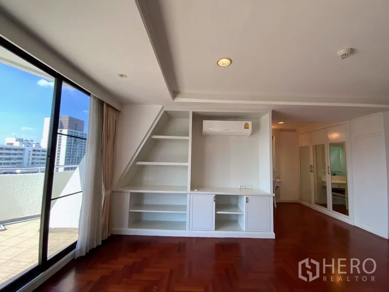 公寓 出租或出售在Watthana, Bangkok - 卧室一角设内置搁架与空调，旁边为采光良好的阳台门。