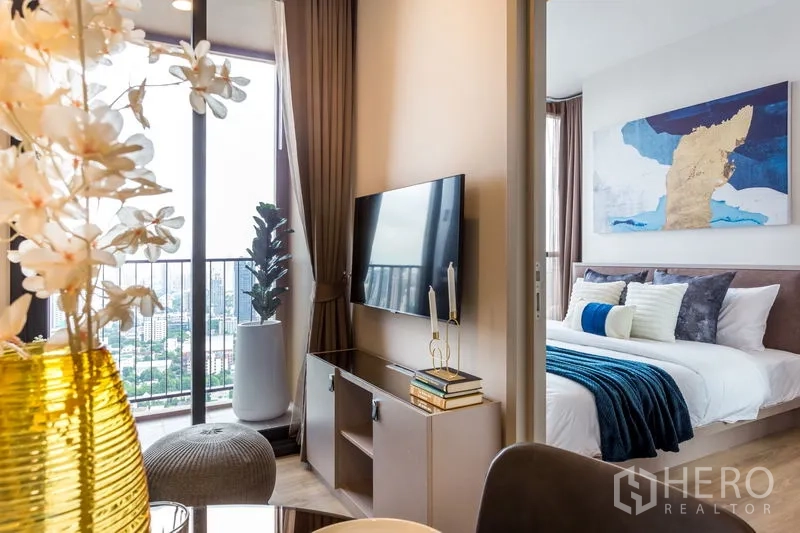 公寓 出租在Khlong Toei, Bangkok - 电视柜位于阳台与主卧之间，配当代艺术装饰。