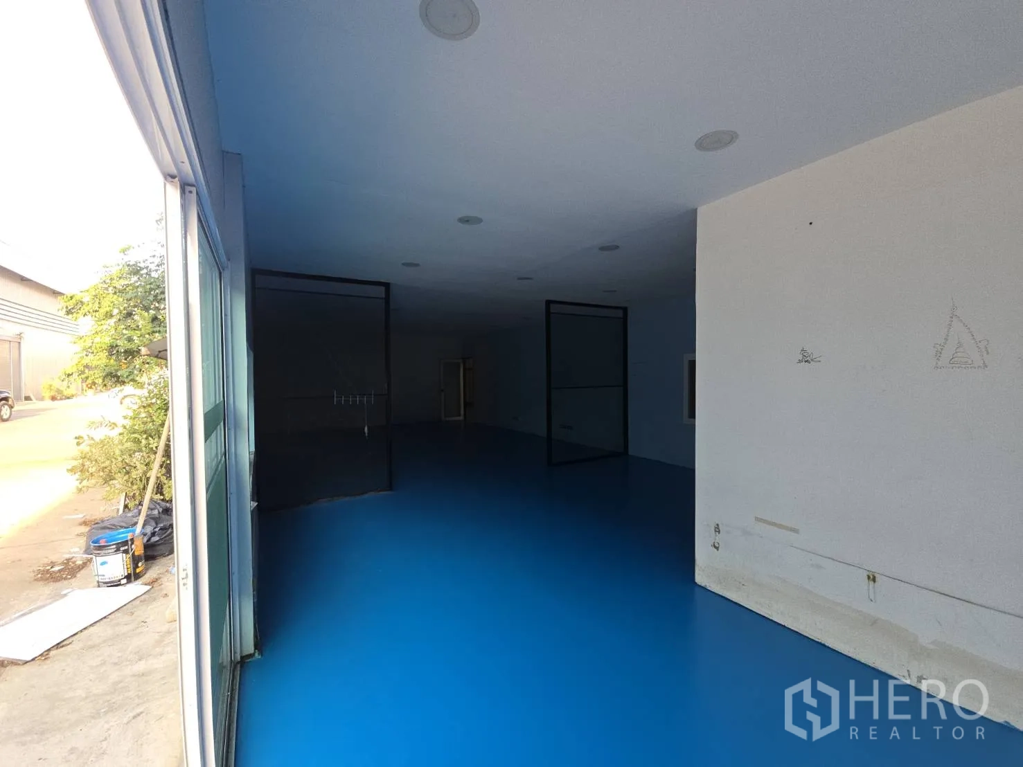 Warehouse for rent in Bang Phli, Samut Prakan - Entrance view toward the office area opening to an exterior yard through sliding glass doors.