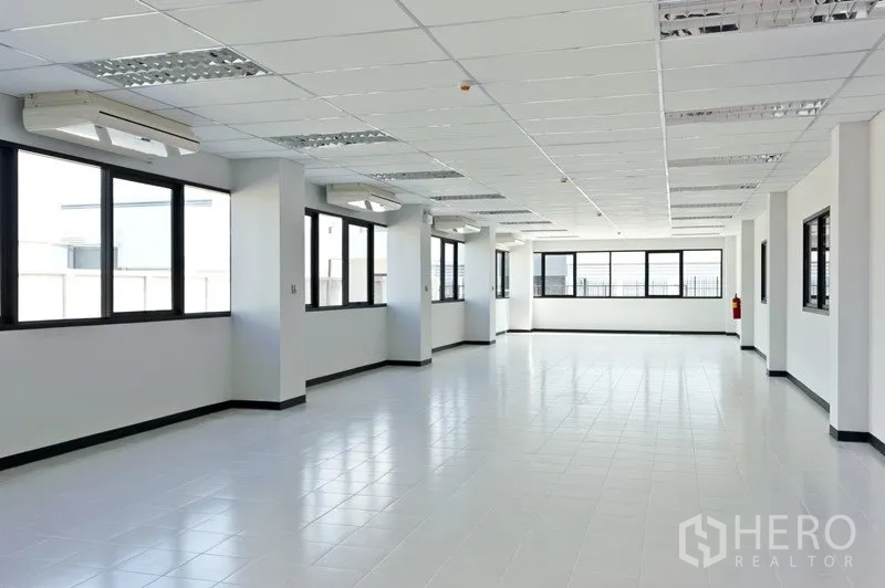 Factory for rent or sale in Samut Prakan - Bright tiled office floor with large windows and multiple ceiling air conditioners.